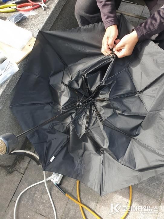 고장 난 우산을 수리하는 모습
