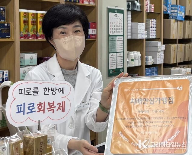 철마면 고촌약국 김수정 대표가 기장군 치매안심가맹점 지정 현판을 전달받고 있다