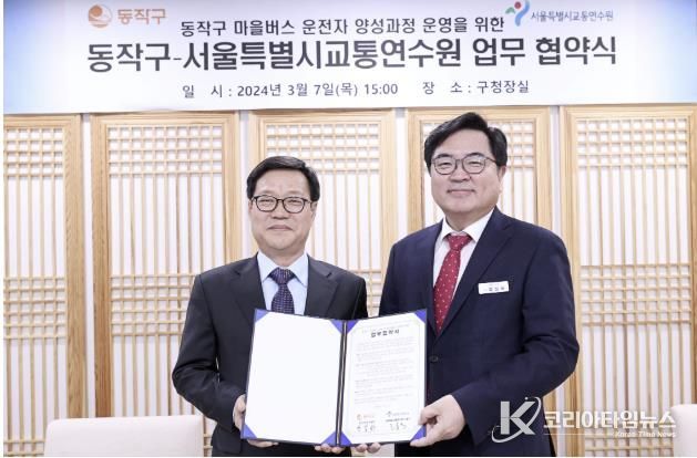 박일하 동작구청장(오른쪽)이 지난해 3월 고홍석 서울시 교통연수원장(왼쪽)과 업무협약을 체결한 후 기념 촬영하고 있다.