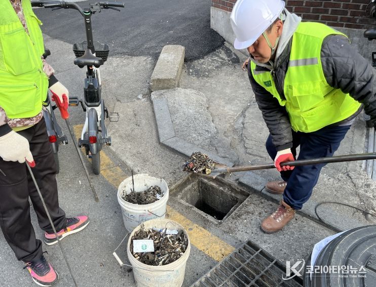 성북구가 장마철 침수 피해 예방을 위해 빗물받이 대청소와 점검을 실시하는 가운데, 작업자들이 빗물받이 내부 이물질을 제거하고 준설 차량을 활용해 배수 상태를 점검하고 있다.