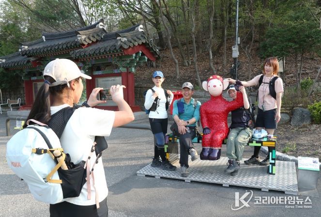 관악산 등산로 입구 으뜸공원에 설치된 작품 ‘하이’와 함께 기념사진을 촬영하는 등산객들