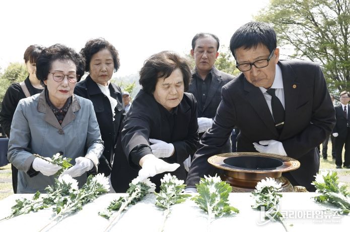 유가족과 참석자들이 제암리 순국 묘역에서 국화를 헌화하며 추모하고 있다